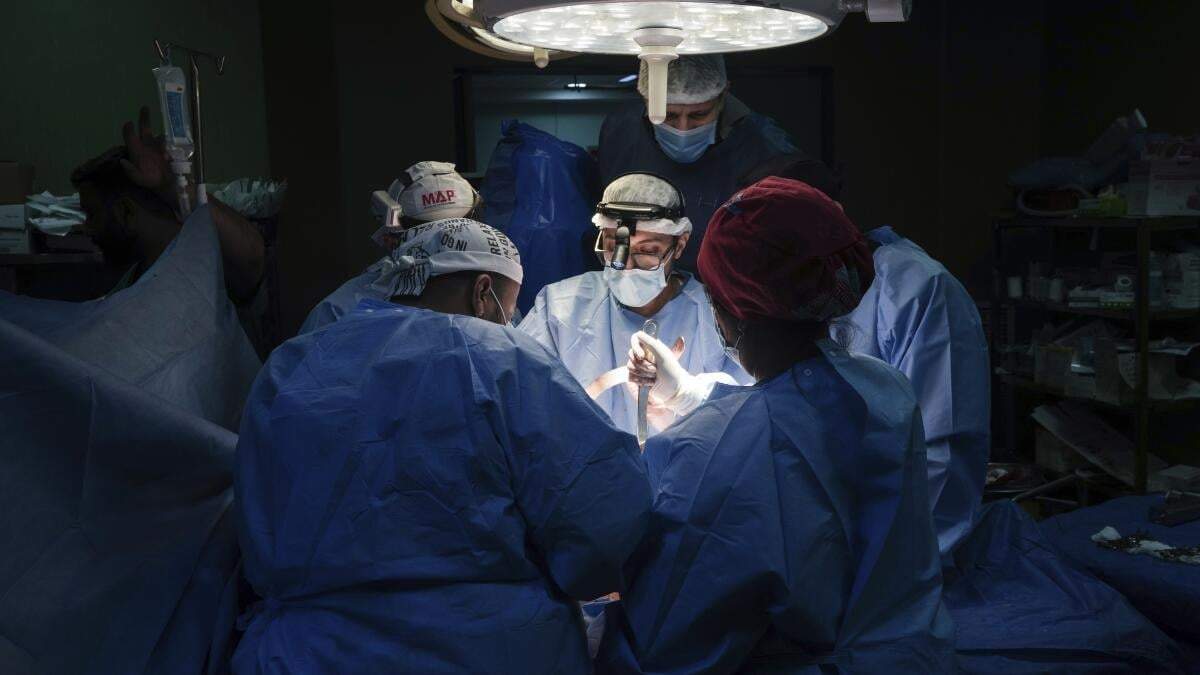 Doctores operan a un paciente en el hospital Mártires de Al-Aqsa, en Deir al-Balah, Gaza, el 17 de marzo de 2024. Un equipo internacional de médicos pasó dos semanas trabajando en el recinto hospitalario en medio de una escasez de suministros