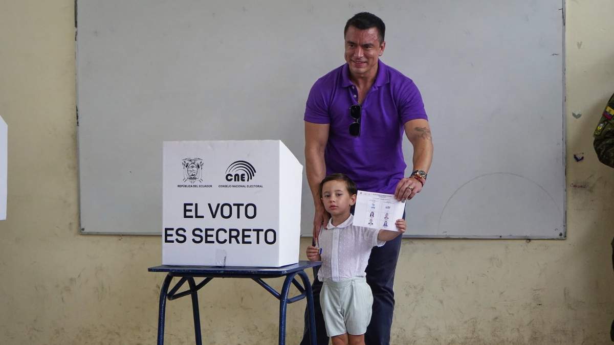 Daniel Noboa muestra sus papeletas electorales antes de votar, acompañado de sus hijos