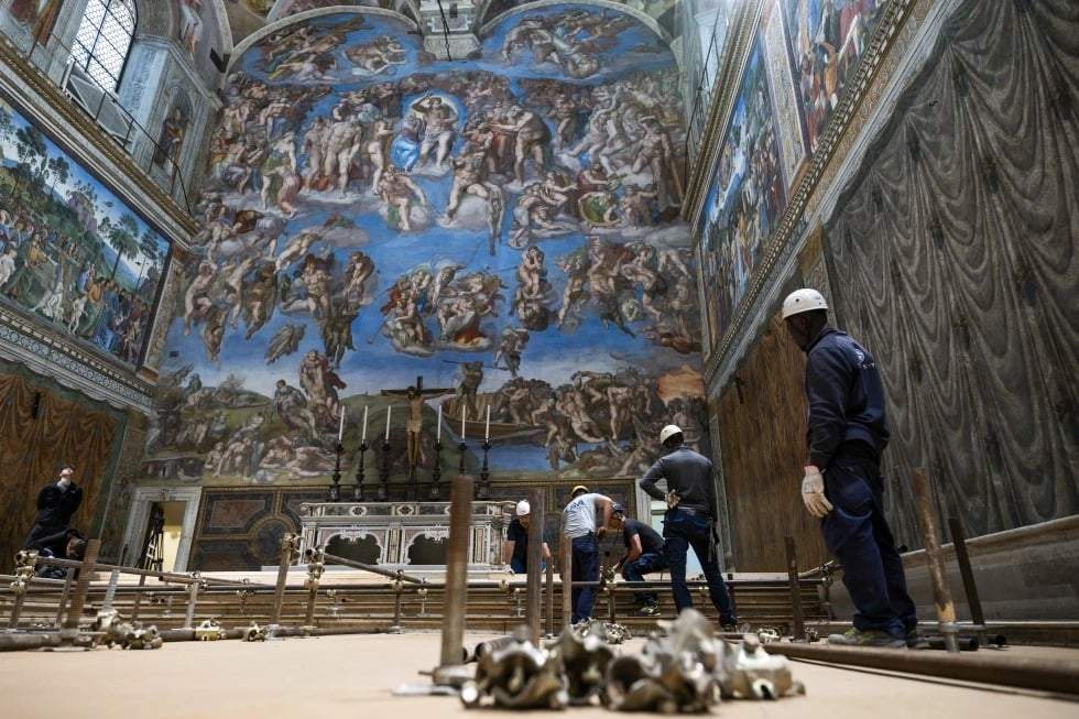 En esta imagen del lunes 28 de abril de 2025, varios trabajadores preparan la capilla Sixtina en el Vaticano, donde comenzará el próximo cónclave el 7 de mayo, ante el fresco de Miguel Ángel “El juicio final”.