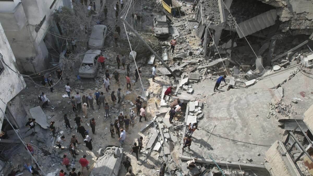 Palestinos buscan sobrevivientes tras un bombardeo israelí en la Franja de Gaza, en Deir al Balah