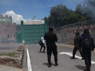 Padres de los 43 bloquean autopista del Sol; normalistas lanzan petardos a cuartel militar