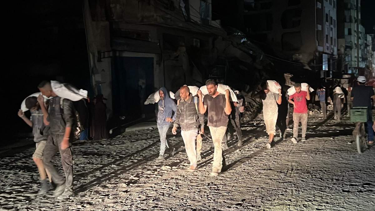 Palestinos cargan los suministros que pudieron conseguir de un centro de ayuda en Gaza