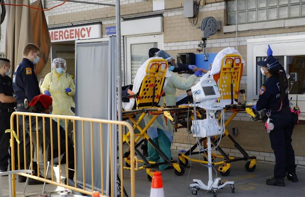 La paramédica de Nueva York Elizabeth Bonilla, a la derecha, lleva a un paciente a la zona de ingresos de urgencias en el Hospital Montefiore