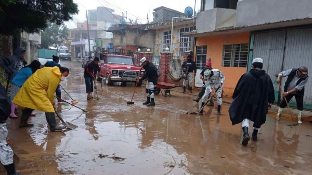 Elementos de la Guardia Nacional ayudan a limpiar una calle en Veracruz