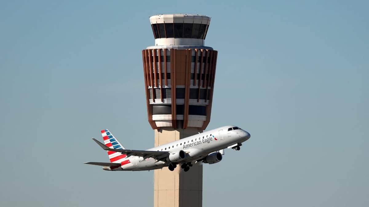 Un avión American Eagle de American Airlines pasa por la torre de control de tráfico aéreo en el Aeropuerto Internacional Phoenix Sky Harbor, el sábado 8 de noviembre de 2025, en Phoenix