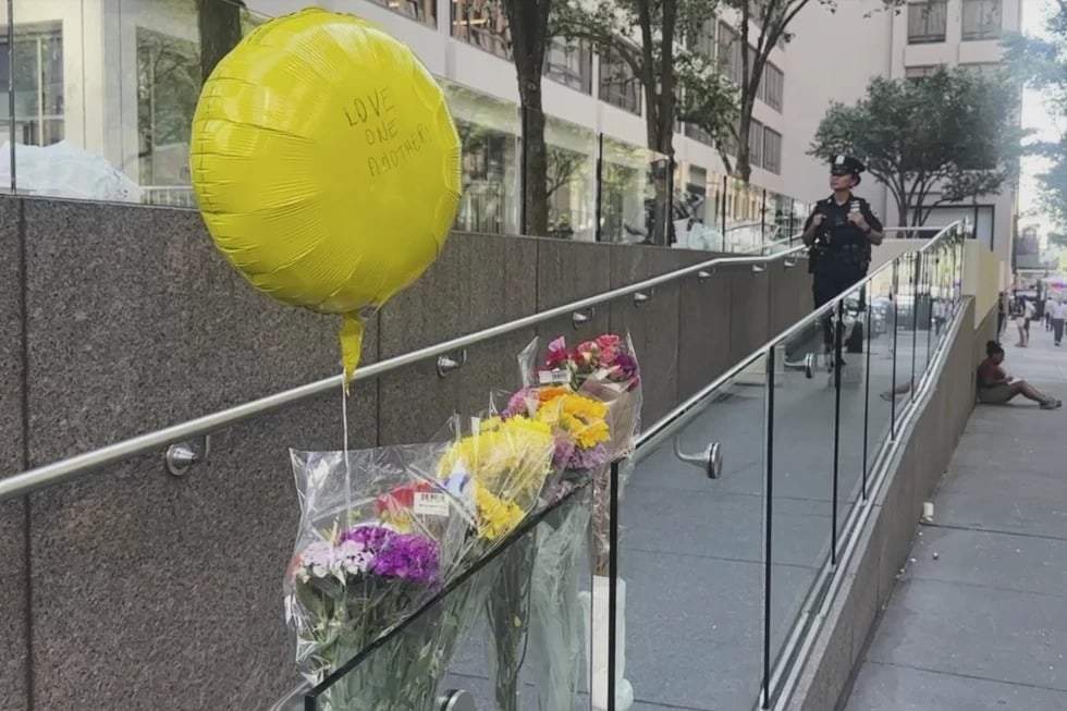 Un agente de policía junto a un monumento improvisado frente al lugar del tiroteo mortal del lunes, el martes 29 de julio de 2025, en Nueva York.