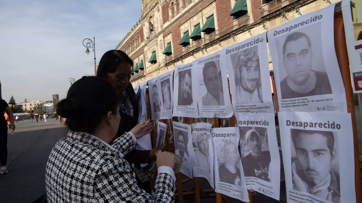 Familiares de personas desaparecidas colocan imágenes de las víctimas frente a Palacio Nacional durante una protesta en 2024