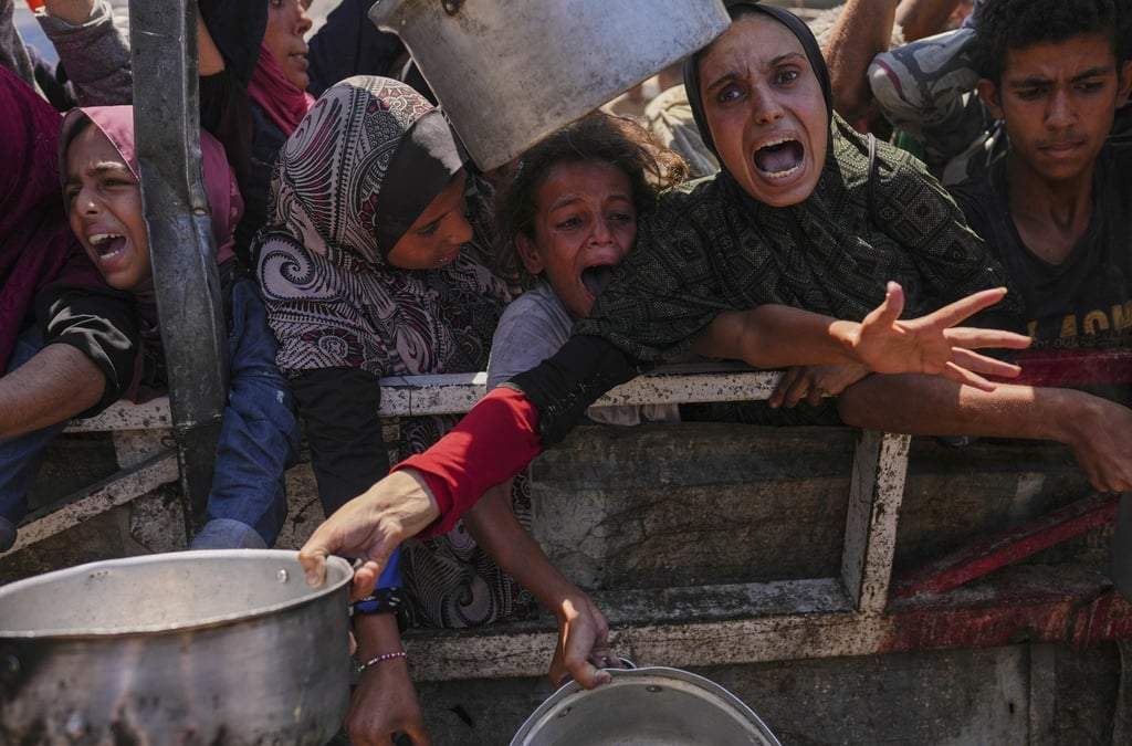 Palestinos luchan por obtener alimentos donados en una cocina comunitaria en Ciudad de Gaza, en el norte del enclave, el lunes 4 de agosto de 2025