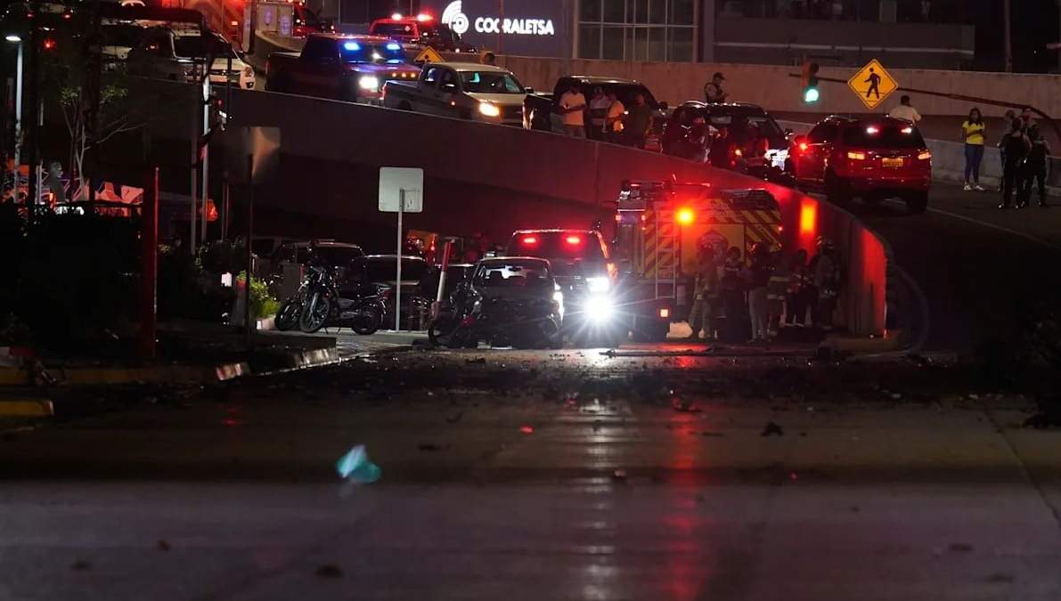 Policías, bomberos y agentes de seguridad inspeccionan los daños en el lugar de la explosión de un automóvil en una calle comercial de Guayaquil, Ecuador