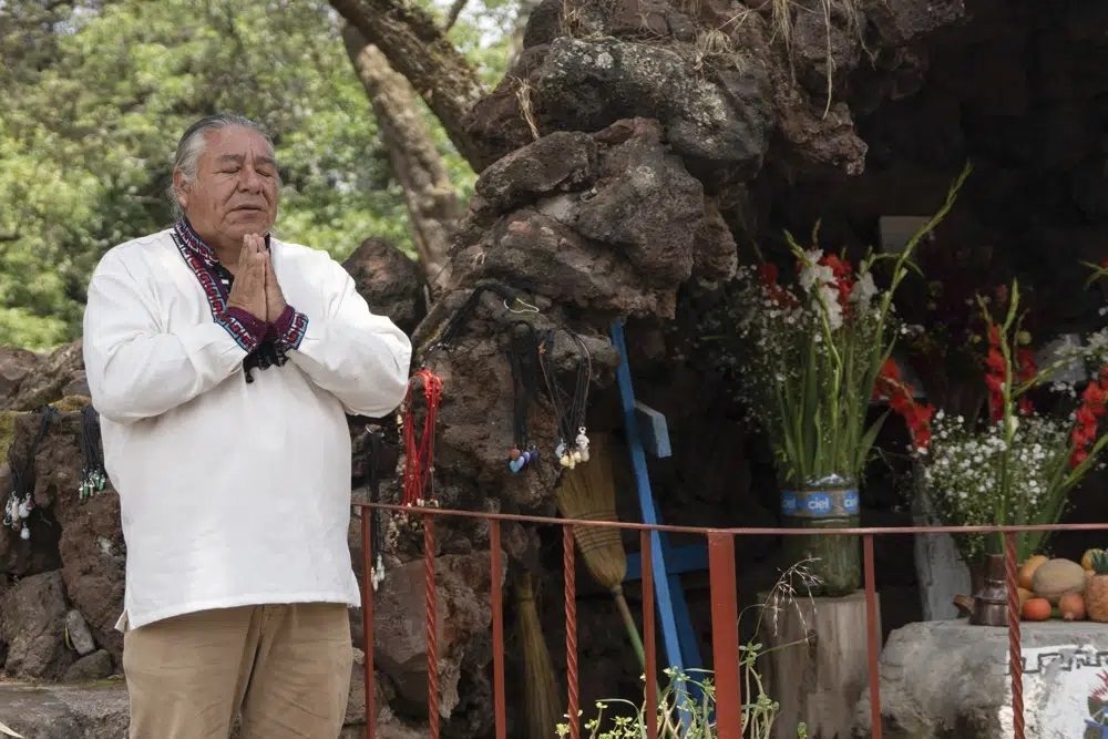 Moisés Vega agradece por los visitantes del Museo del Volcán junto a una réplica del santuario que la gente le dedica al volcán Popocatépetl, en Amecameca, México, el domingo 11 de junio de 2023
