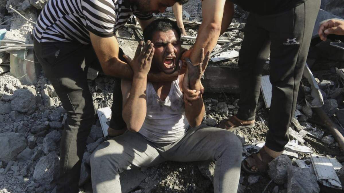 Palestinos consuelan a un hombre que llora después de perder a familiares por bombardeos de Israel en Ciudad de Gaza