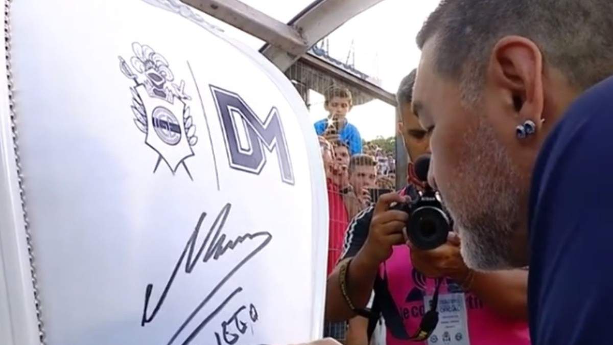 Maradona firmando el sillón. Fuente: (Twitter)