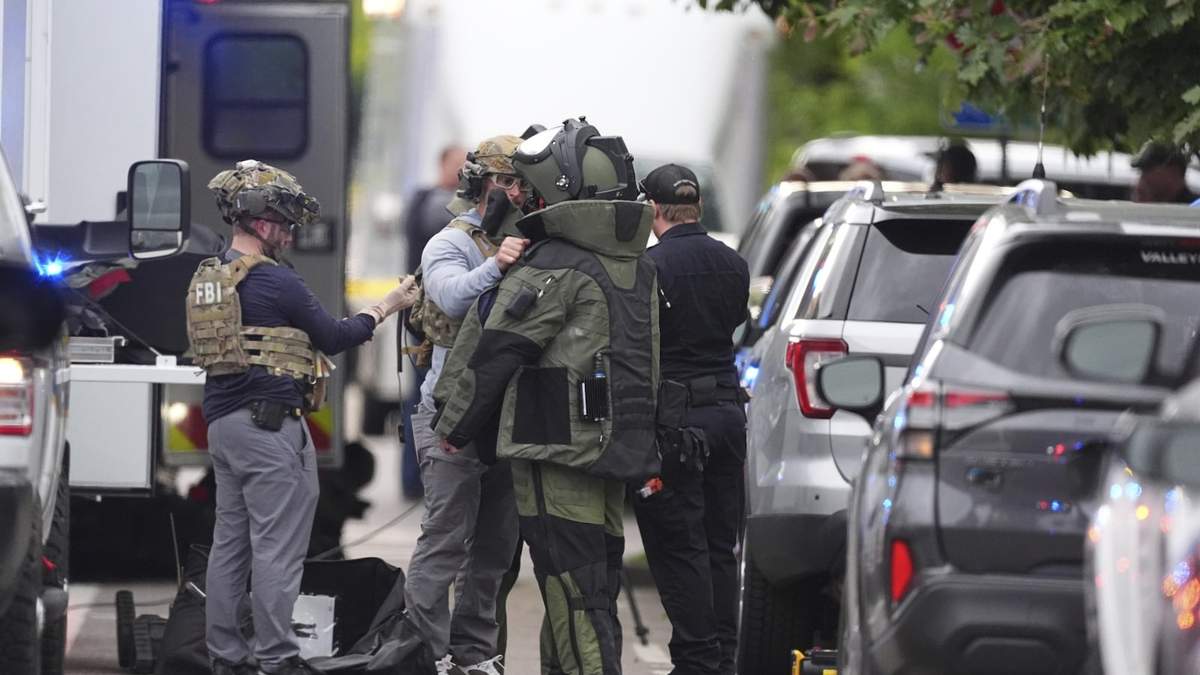 Agentes policiales se colocan equipo de protección para investigar un ataque en el centro comercial Pearl Street Mall