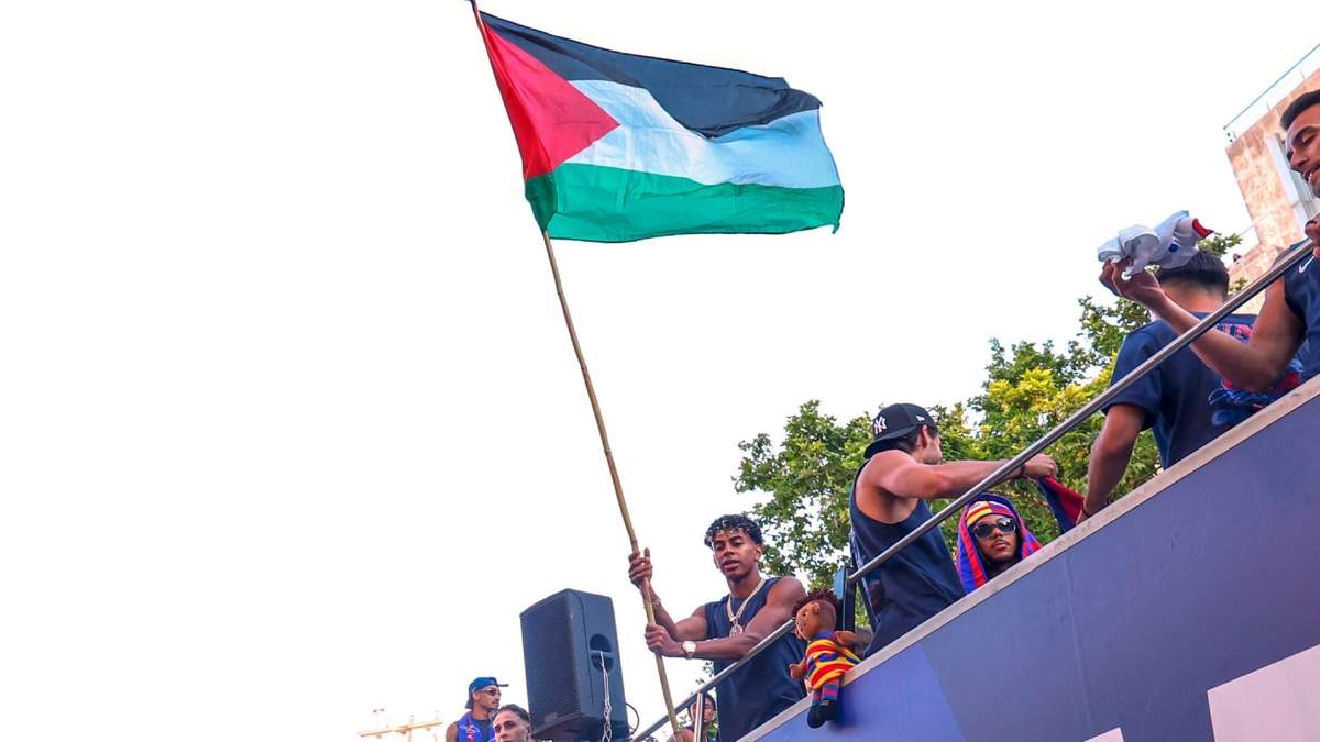El astro del Barcelona Lamine Yamal sostiene una bandera palestina al celebrar la consagración del equipo como campeones de la Liga de España, el lunes 11 de mayo de 2026, en Barcelona