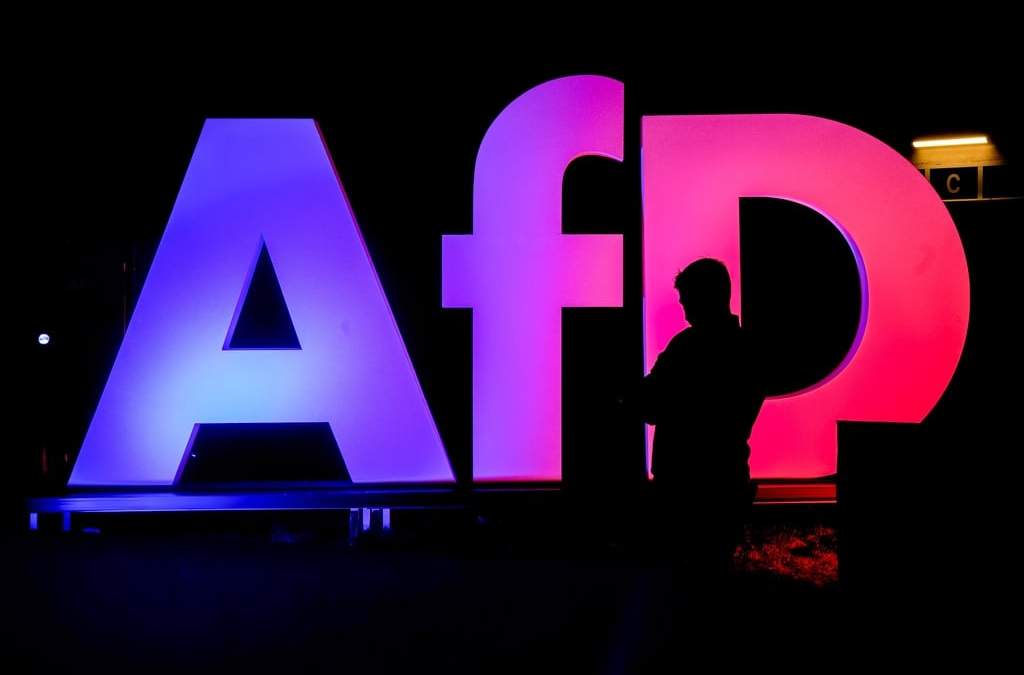 ARCHIVO - Un hombre, frente al logo de AfD en la sede del partido en Berlín, Alemania, el 23 de febrero de 2025, tras las elecciones generales en el país