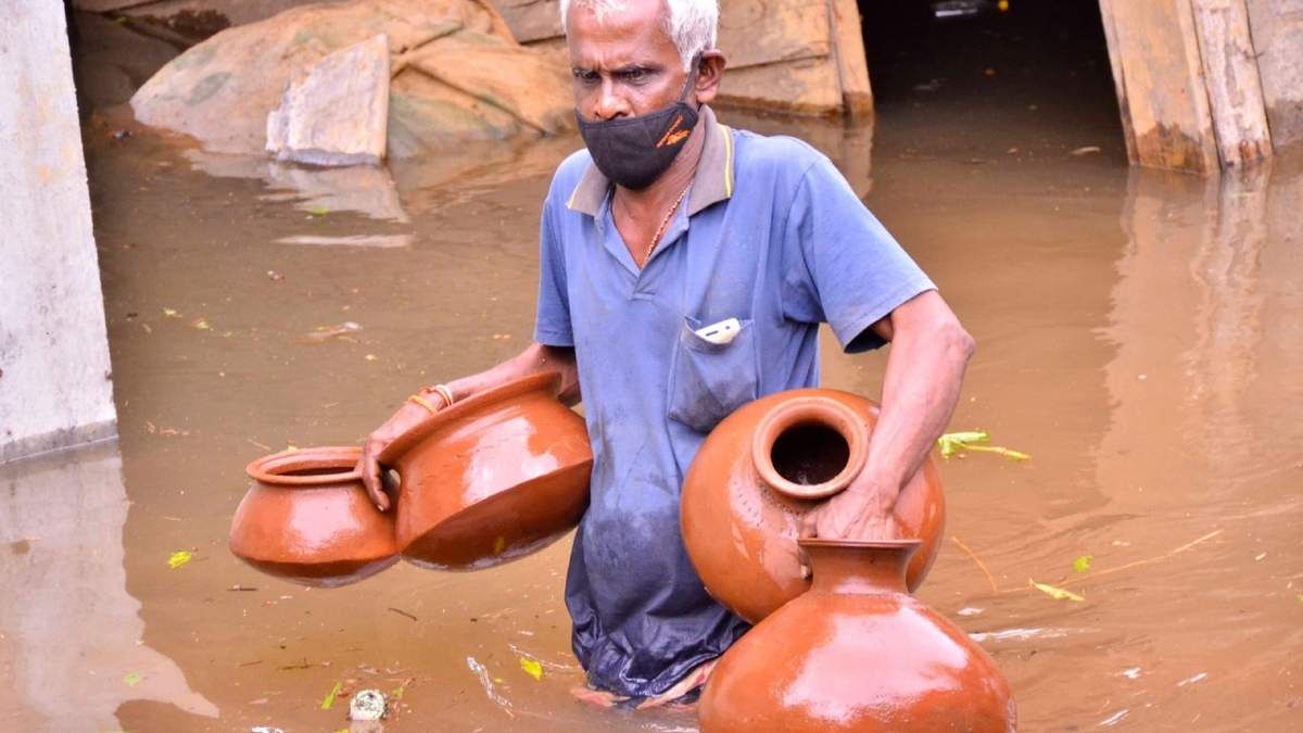 Un hombre intenta salvar sus pertenencia en medio de las inundaciones en India. Fuente: (Twitter)