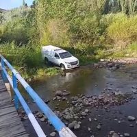 Los Guañacos: una camioneta fúnebre debió atravezar el cauce del río porque está roto el puente