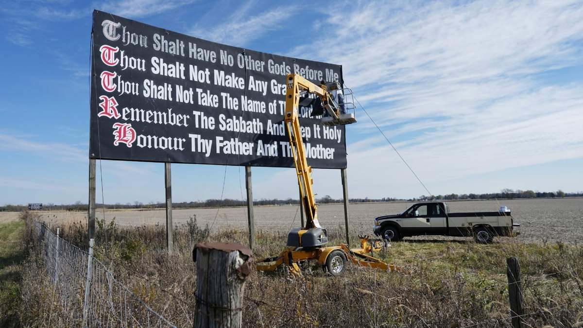 Trabajadores repintan una valla publicitaria de los Diez Mandamientos en Chenoweth, Ohio