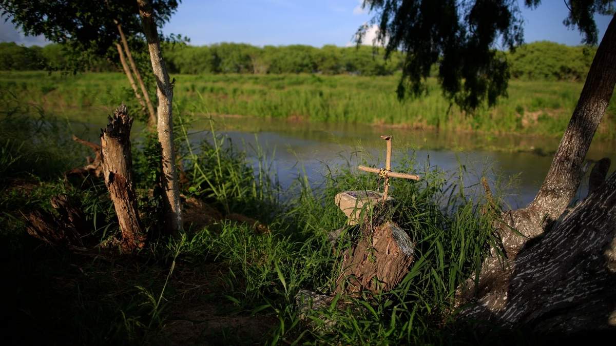 Una cruz marca un monumento funerario en las márgenes del río Bravo