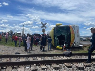 Autobús con pasajeros intentó ganar el paso al tren y terminó arrollado; hay tres muertos