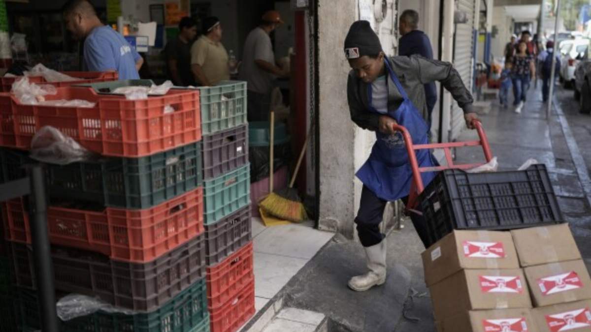 Un trabajador migrante haitiano estiba cajas en una tienda cerca de un mercado en Monterrey