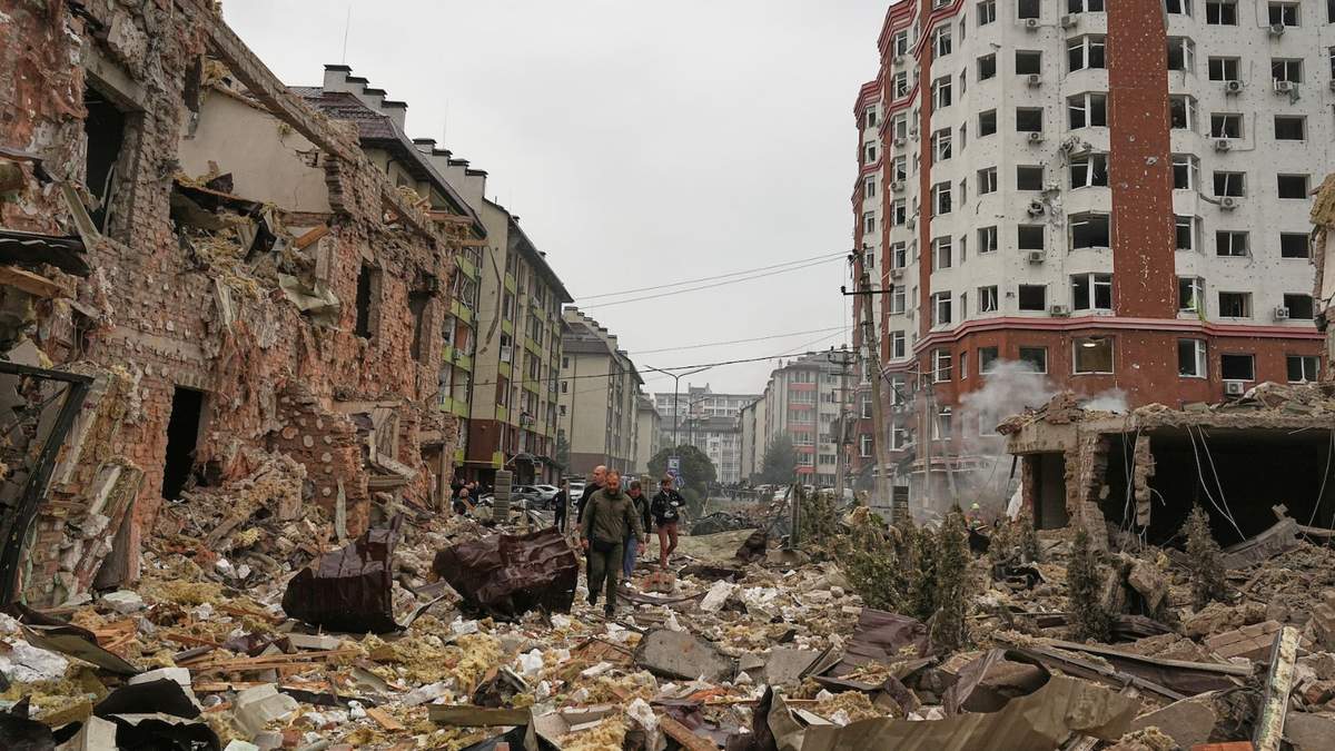 Gente camina cerca de edificios de apartamentos dañados después de un ataque ruso en Kiev, Ucrania