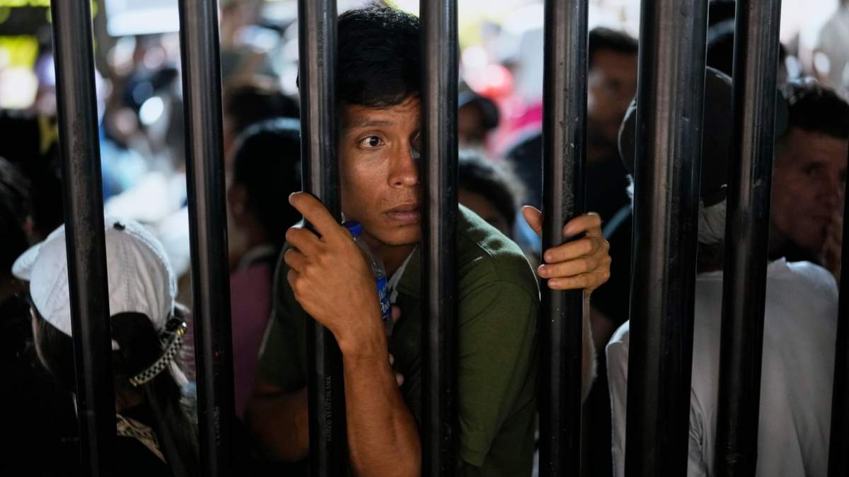 Personas desplazadas por la violencia en pueblos de la región del Catatumbo, donde rebeldes del Ejército de Liberación Nacional se han enfrentado con exmiembros de las Fuerzas Armadas Revolucionarias de Colombia, hacen fila para registrarse para recibir refugio en un estadio en Cúcuta, Colombia