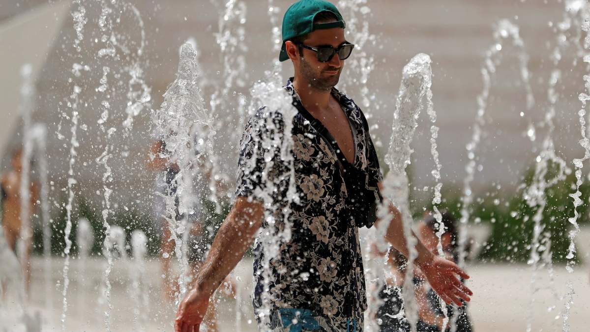 Ciudadanos caminan entre las fuentes de agua para refrescarse por el calor. Fuente: (Twitter)