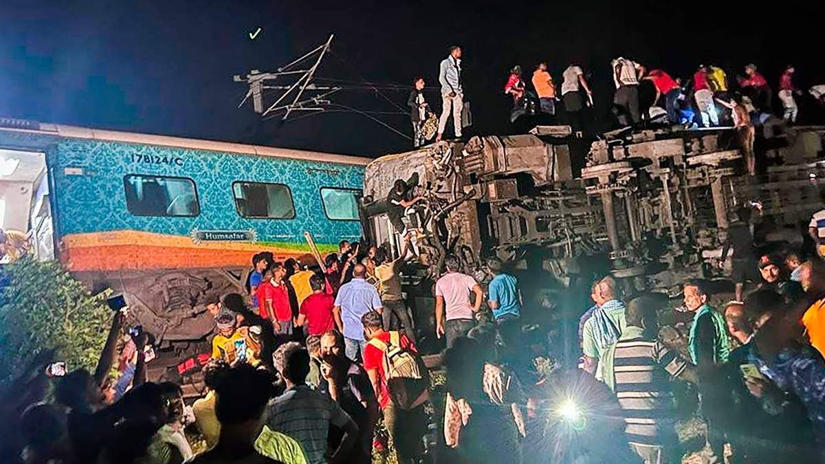 Civiles y rescatistas laboran en el sitio donde descarrilaron dos trenes en India