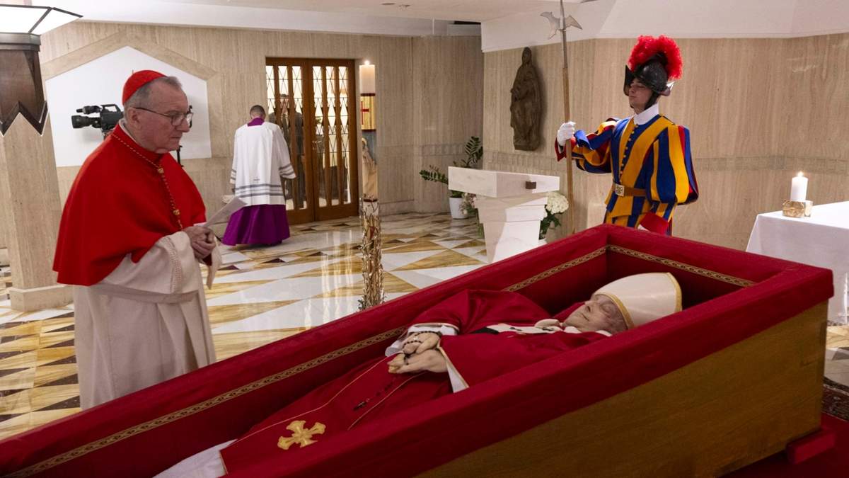 El secretario de Estado del Vaticano, el cardenal Pietro Parolin (izquierda), reza en frente del cuerpo del papa Francisco, dispuesto para el velatorio en su capilla privada en el Vaticano, el 21 de abril de 2025