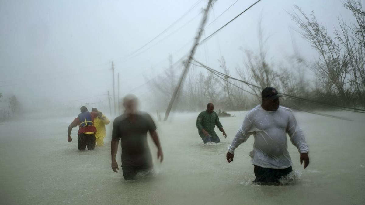 ARCHIVO - Voluntarios vadean una carretera inundada tras el paso del huracán Dorian para rescatar a familias cerca del puente Causarina en Freeport, Gran Bahama, en las Bahamas