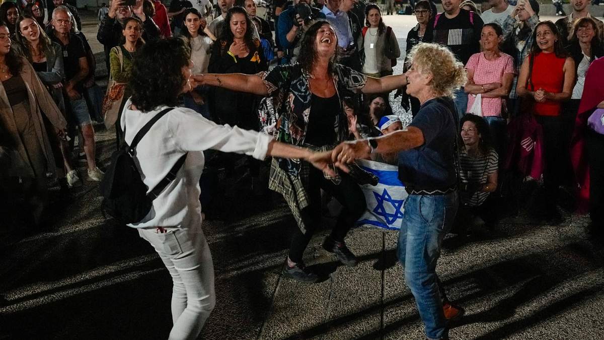 Un grupo de personas celebran la noticia de la liberación de 13 rehenes israelíes que Hamás tenía en la Franja de Gaza