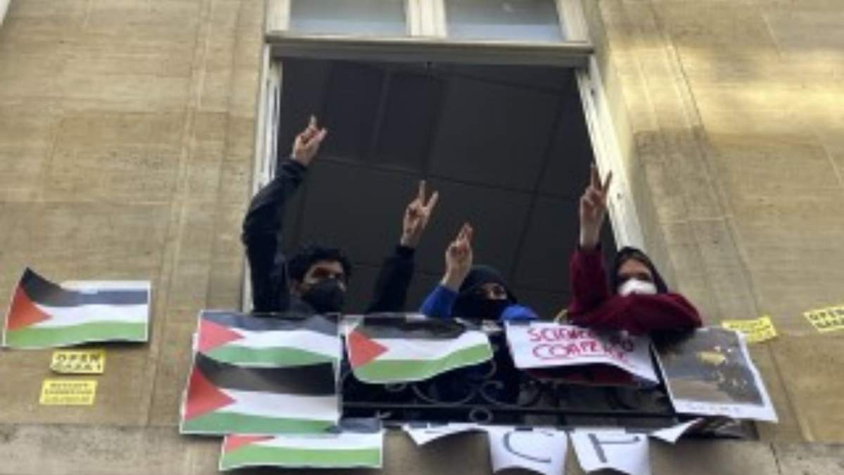 Estudiantes de la Universidad de Ciencias Políticas hace el gesto de la victoria con la mano desde una ventana del centro, en París