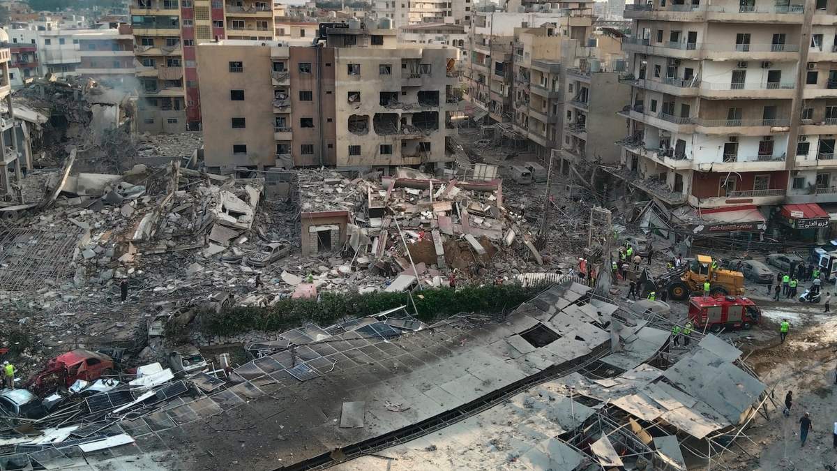 Rescatistas trabajan en el lugar donde un ataque aéreo israelí alcanzó un edificio y dañó un hospital en la ciudad portuaria de Tiro