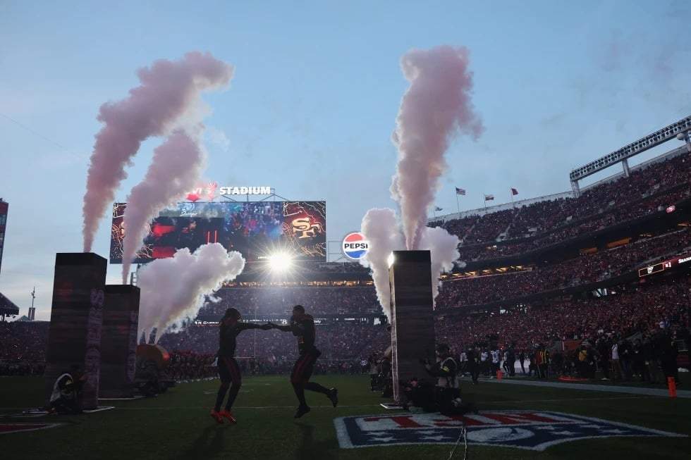 Los receptores abiertos de los San Francisco 49ers, Demarcus Robinson (izquierda) y Kendrick Bourne, saltan al campo antes de un partido de la NFL contra los Seattle Seahawks en Santa Clara, California, el sábado 3 de enero de 2026.