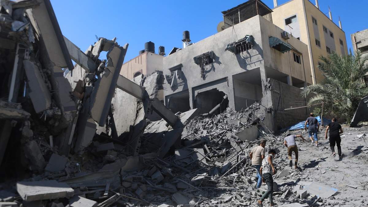 Palestinos inspeccionan los daños de un edificio destruido tras los ataques aéreos israelíes en la ciudad de Gaza, en el centro de la Franja de Gaza