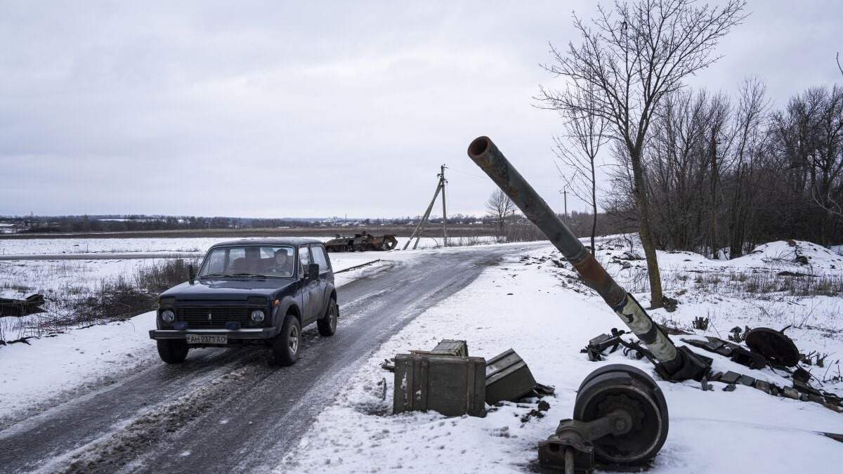 Un auto pasa junto a un tanque destruido en un antiguo puesto de las fuerzas rusas en la localidad de Ridkodub