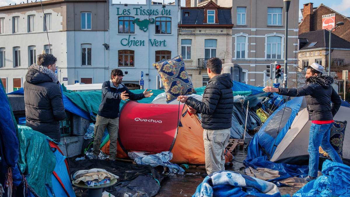 Hombres se instalan en un campamento improvisado frente al centro de recepción Petit Chateau en Bruselas