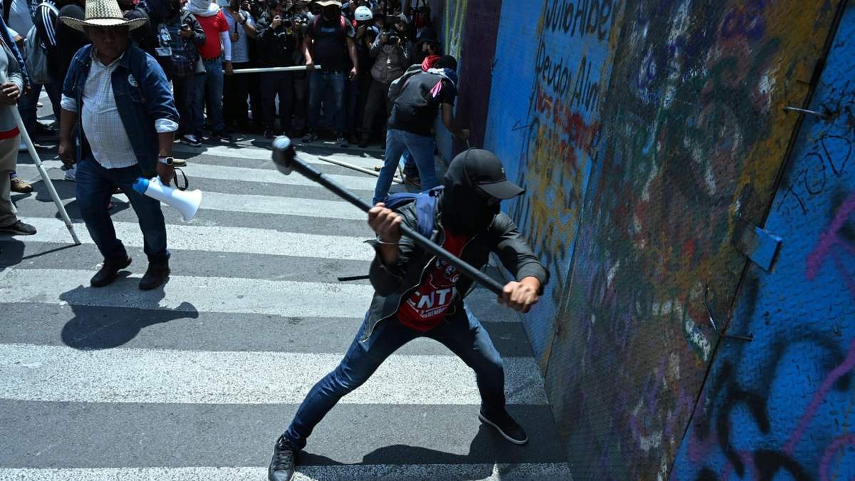 Maestros de la CNTE intentaron derribar las vallas con mazos