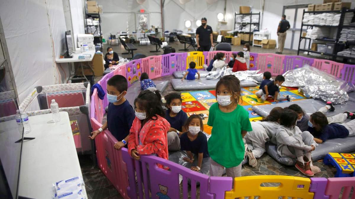 Niños migrantes ven televisión en un centro del servicio de inmigración estadounidense en Donna, Texas, el 30 de marzo del 2021