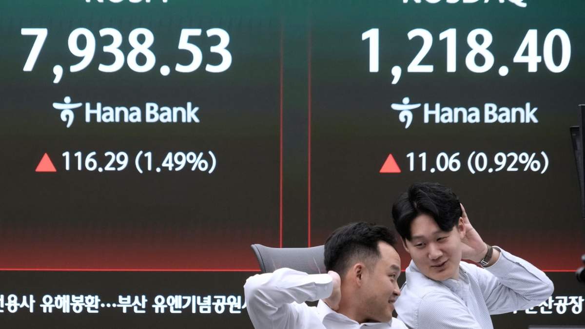 Operadores de divisas reaccionan junto a una pantalla con el índice surcoreano Korea Composite Stock Price Index (KOSPI), a la izquierda, en la sala de operaciones del banco Hana en Seúl, Corea del Sur, el martes 12 de mayo de 2026