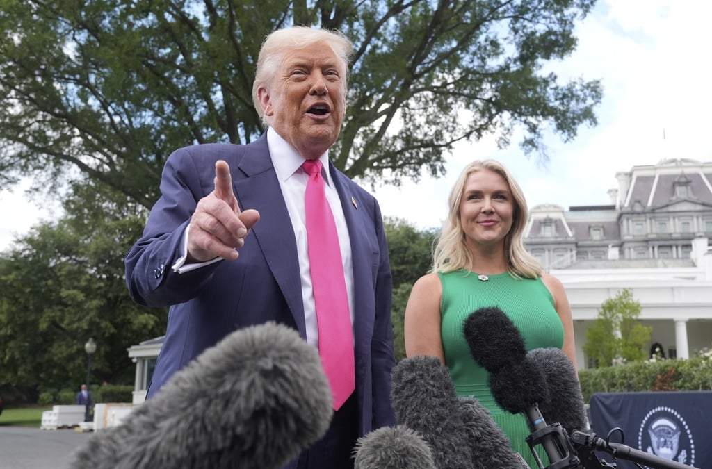 El presidente Donald Trump habla con la presa a su salida de la Casa Blanca, mientras la secretaría de prensa de la Casa Blanca, Karoline Leavitt lo observa, el martes 15 de julio de 2025