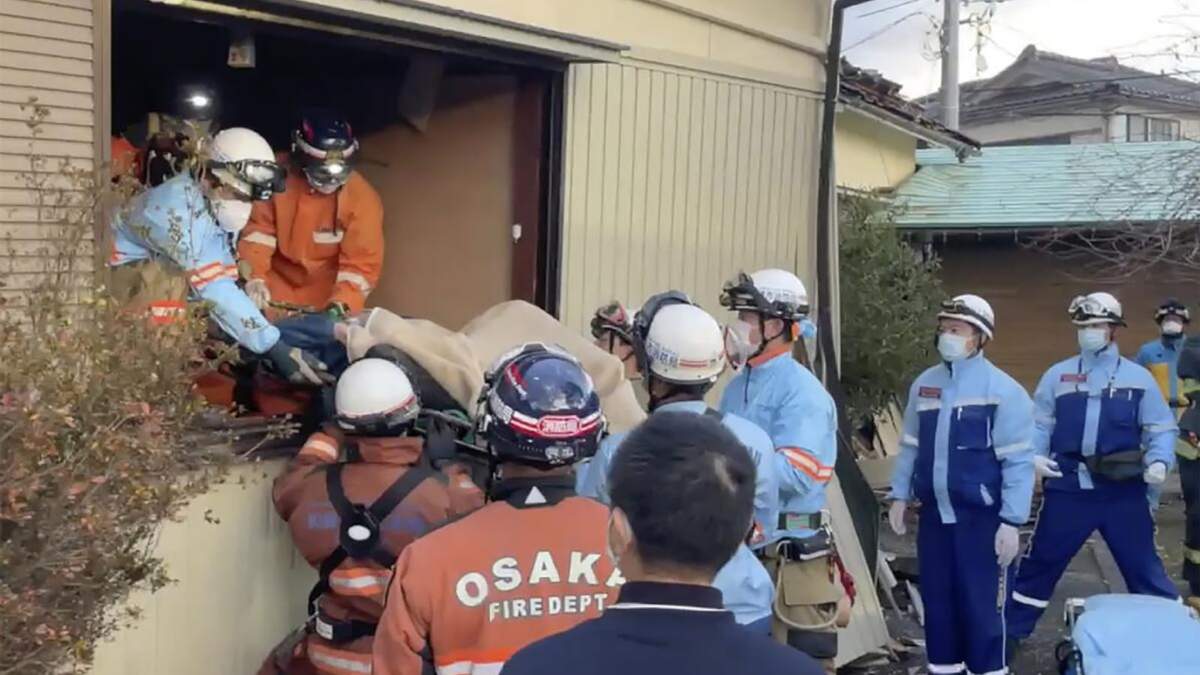 Una mujer es sacada en camilla tras ser encontrada bajo su casa destruida 72 horas después de un potente sismo en Wajima, en la prefectura de Ishikawa
