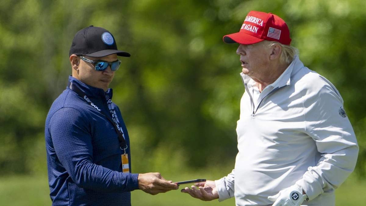 Walt Nauta toma el celular de Donald Trump en un torneo de golf en mayo de 2023
